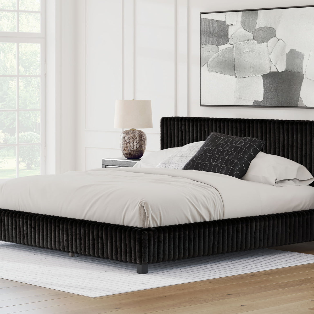 Black upholstered bed with white bedding and two pillows, ribbed headboard