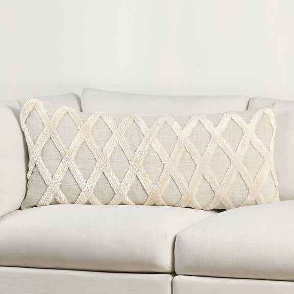 Natural ivory lumbar pillow on sofa with raised diamond embroidery and fringed borders