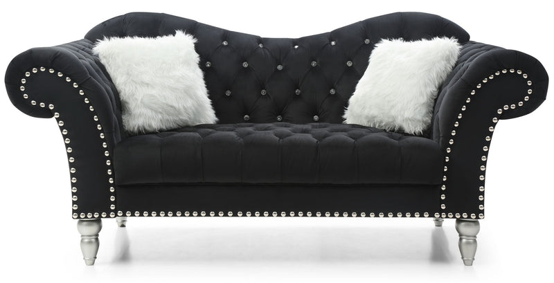 Black tufted round arm loveseat with nailhead trim and two white faux fur pillows.