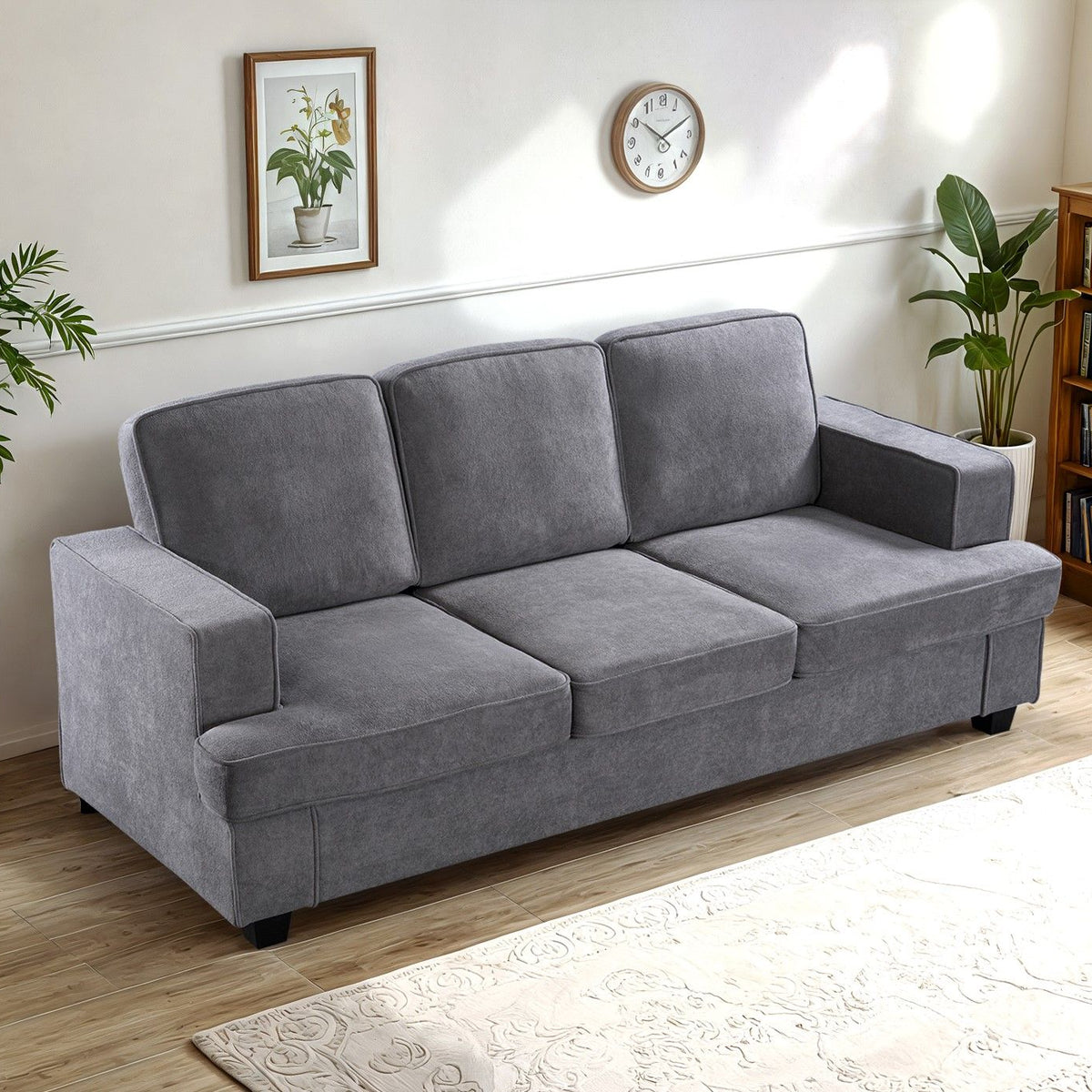 3-seater sofa in charcoal gray fabric with loose back cushions and wide arms.