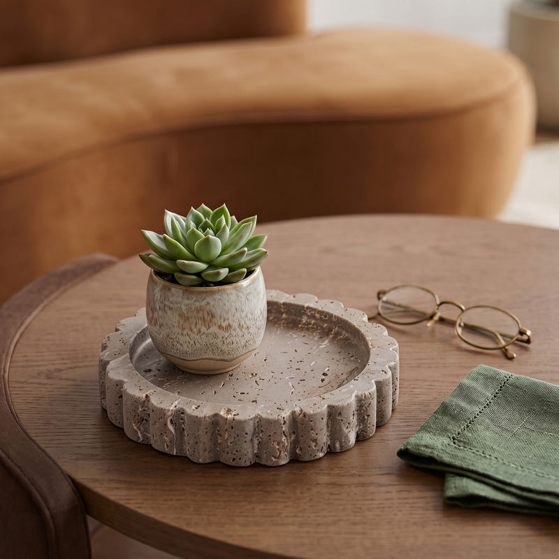 Beige travertine serving tray with scalloped rim centered on a wooden table