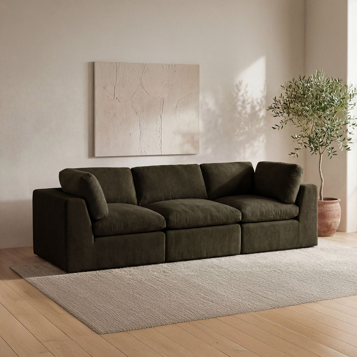 Dark green upholstered sectional sofa with chaise and wide back cushions