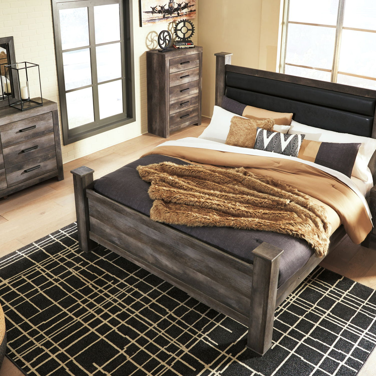 Gray upholstered poster bed with tall headboard and footboard, styled with bedding set
