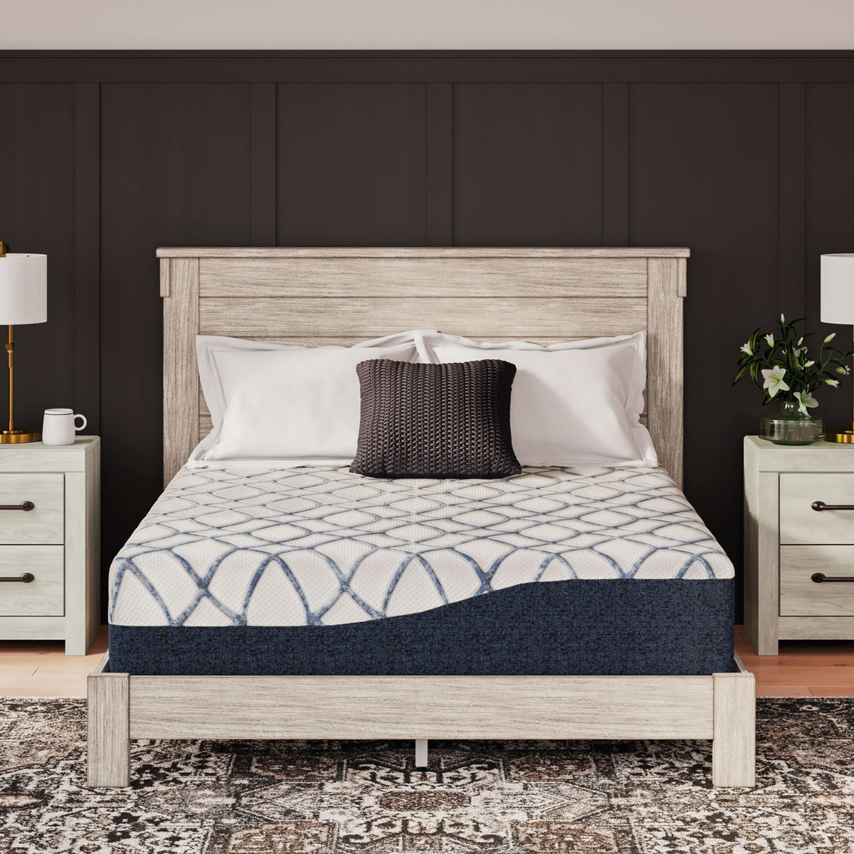 Twin-size mattress on a bed frame, blue-and-white patterned cover with gray border.