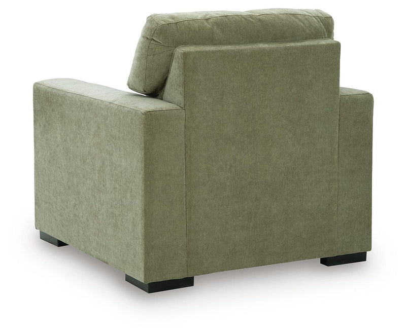Moss green upholstered armchair with rounded top back and black feet