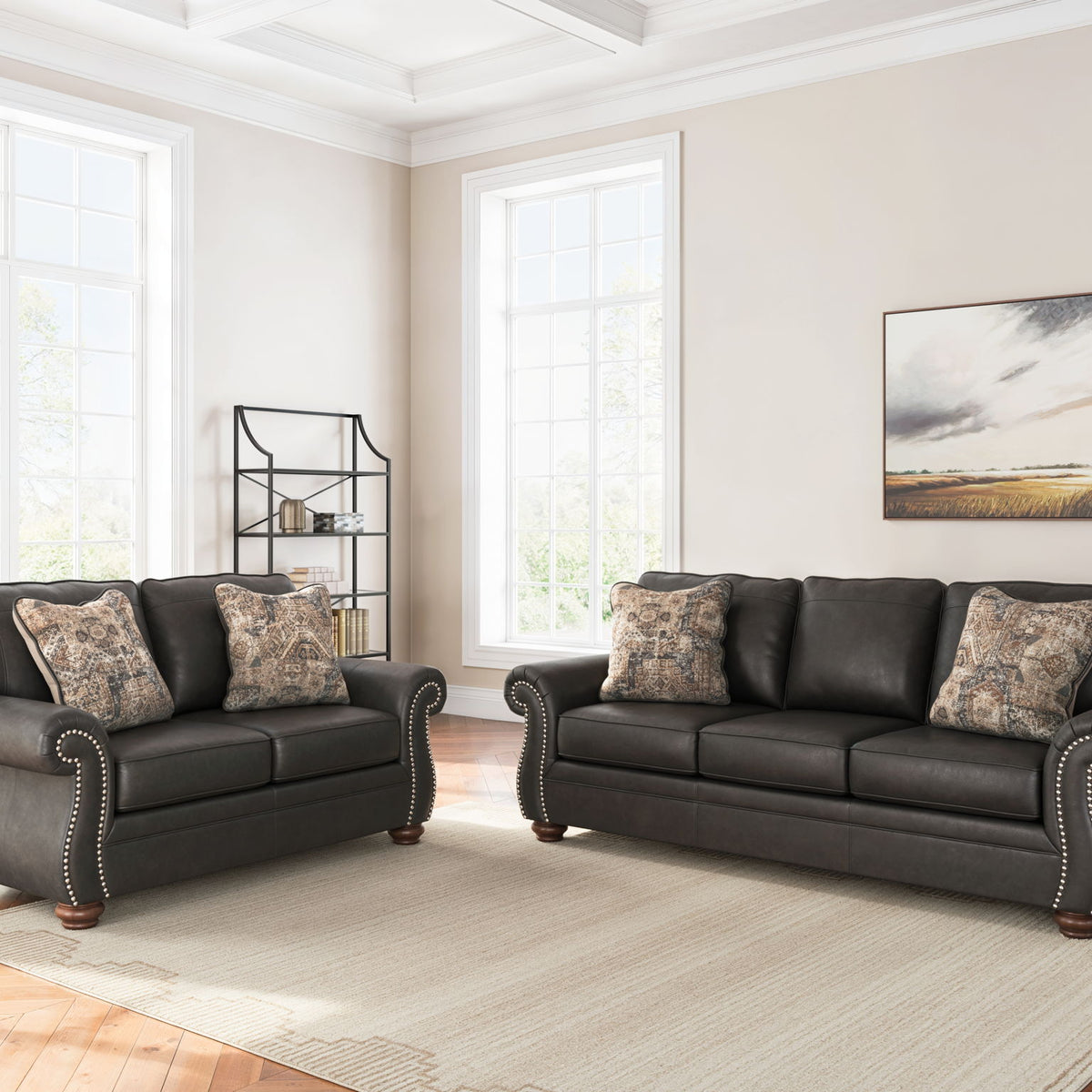 Living room sofa set with two dark sofas and patterned throw pillows