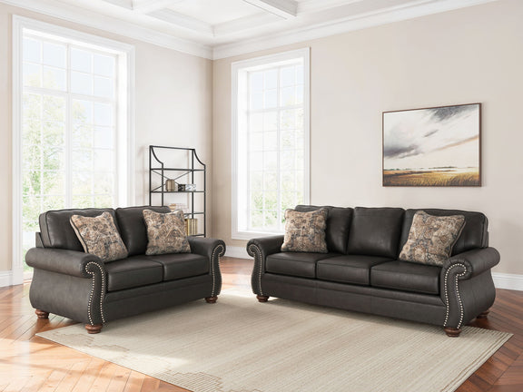 Living room sofa set with two dark sofas and patterned throw pillows