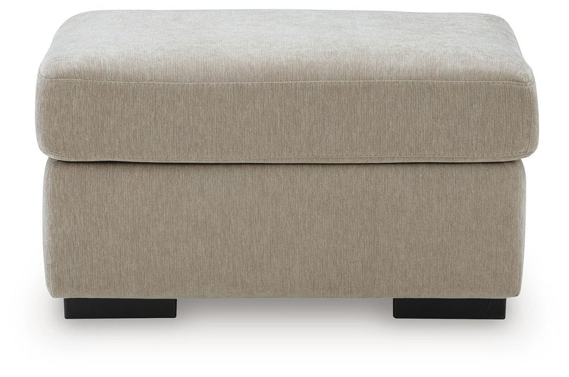 Light brown upholstered ottoman with rounded lid and dark legs