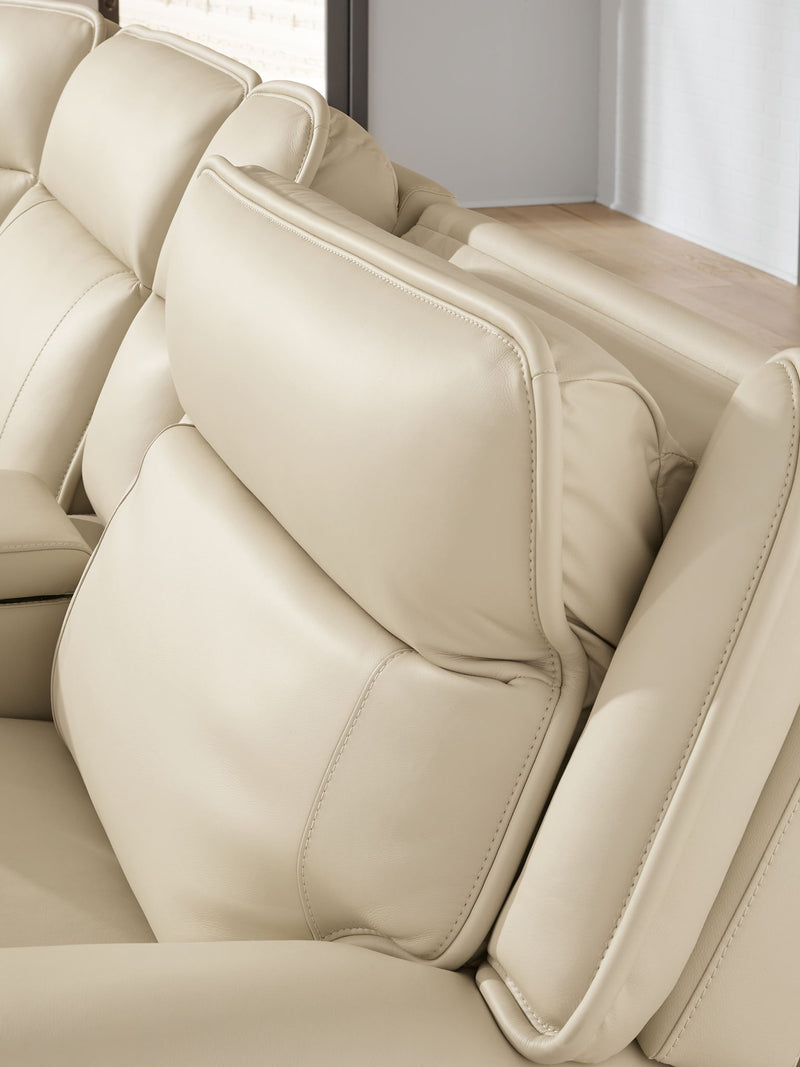Beige upholstered armrest and backrest cushions on a power reclining sectional.