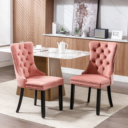 Pink tufted dining chair with buttoned back, nailhead trim, and wooden legs