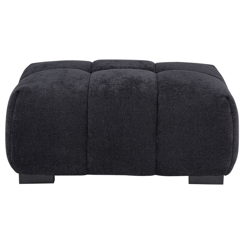 Dark gray rectangular upholstered ottoman with tufted top panels and low black legs.