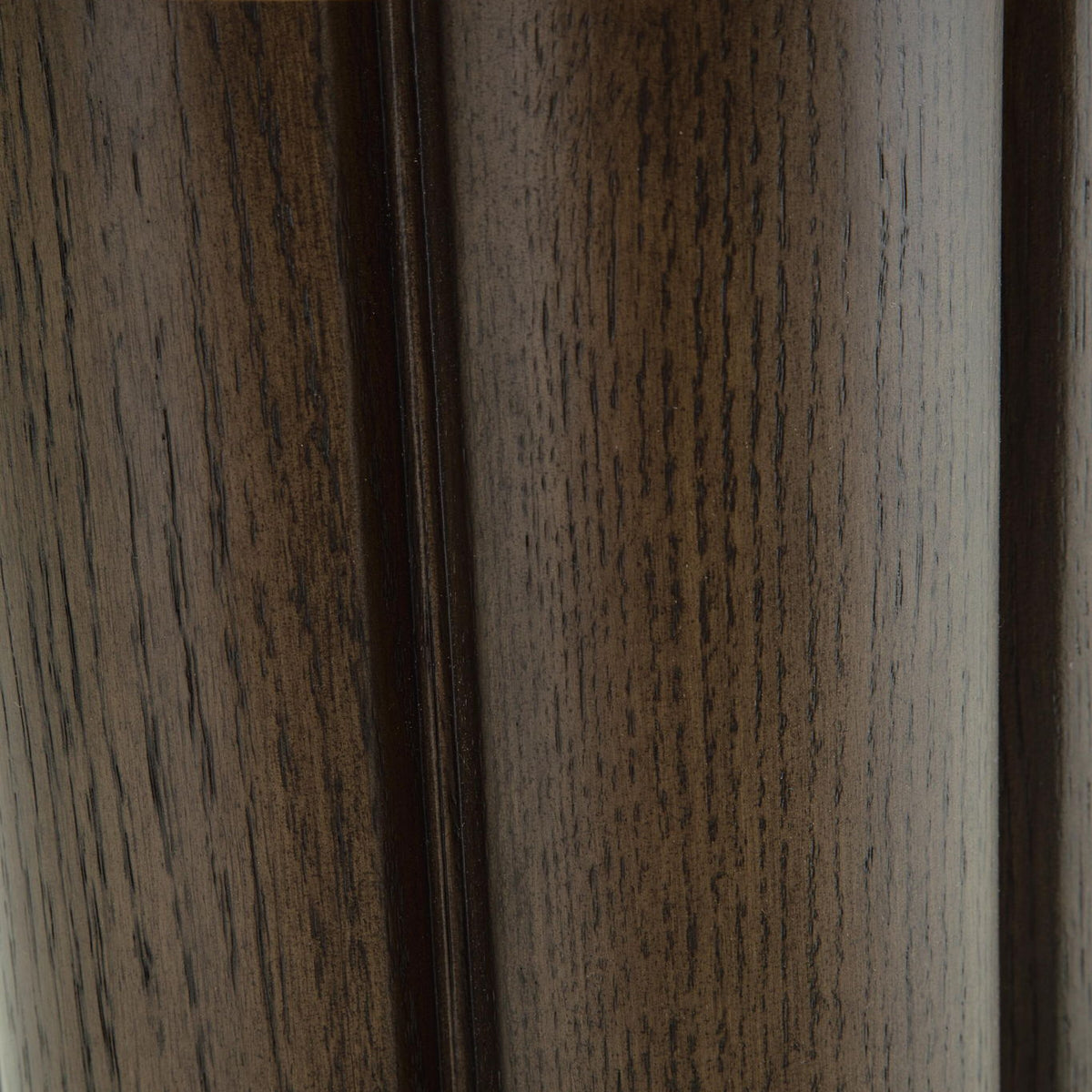 Close-up of dark brown wood pedestal legs with textured vertical grain