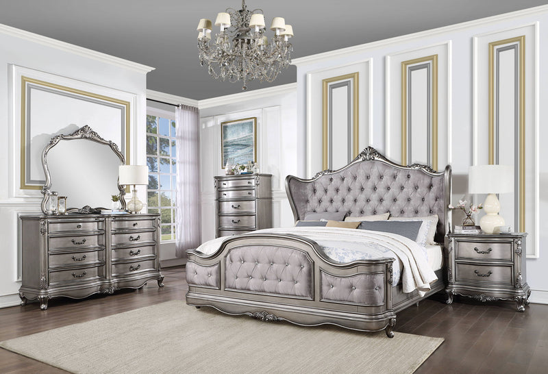 Silver tufted upholstered bed with carved frame and curved headboard