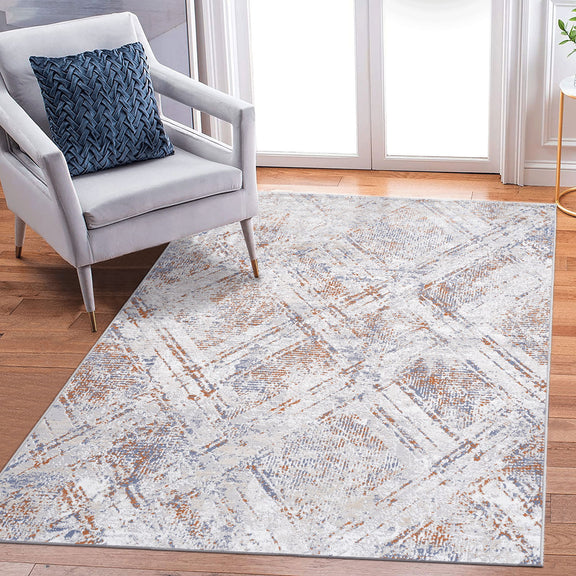 Beige geometric area rug with distressed abstract lines and orange-brown highlights.