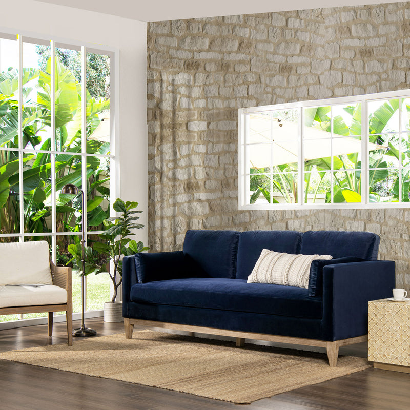 Modern farmhouse sofa in dark blue with plush cushions and low wooden legs