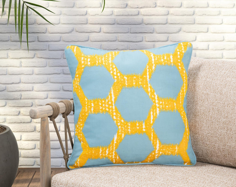 Blue decorative pillow with yellow lattice geometric design and piped border