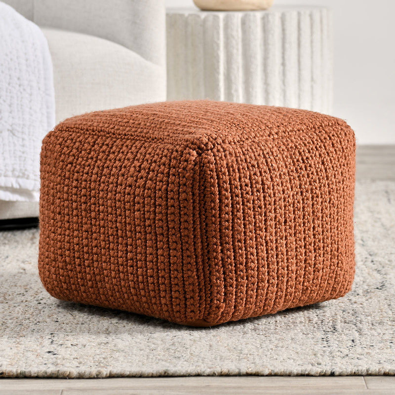 Terracotta knitted pouf with ribbed texture and rounded cylindrical shape