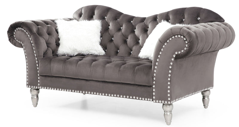 Gray velvet round arm loveseat with tufted back, nailhead trim, and two white faux fur pillows.