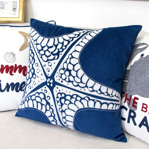 Indigo blue pillow cover with white starfish motifs and navy corner border