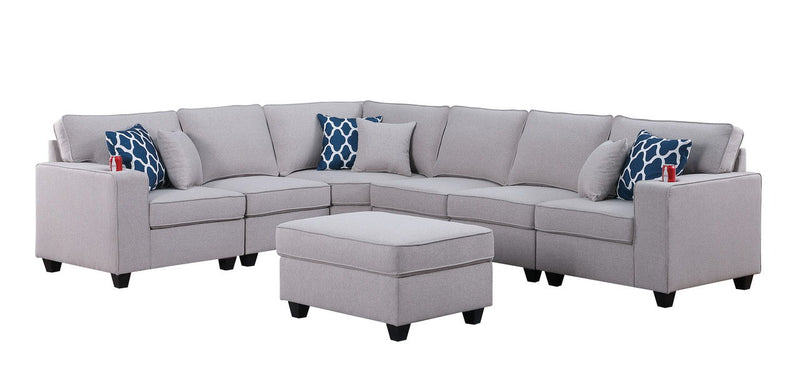 Gray sectional sofa with ottoman and blue patterned throw pillows, curved corner layout