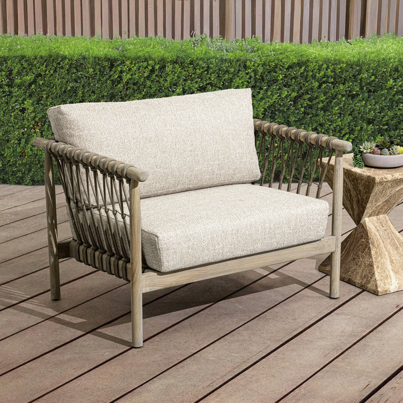 Outdoor accent chair with woven sides, light taupe cushions, and squared wooden frame