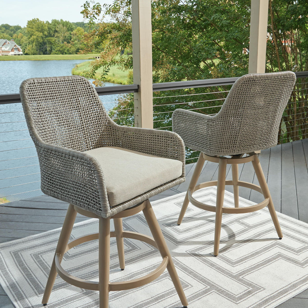 Set of two woven barstools with beige seat cushions and light wood frames