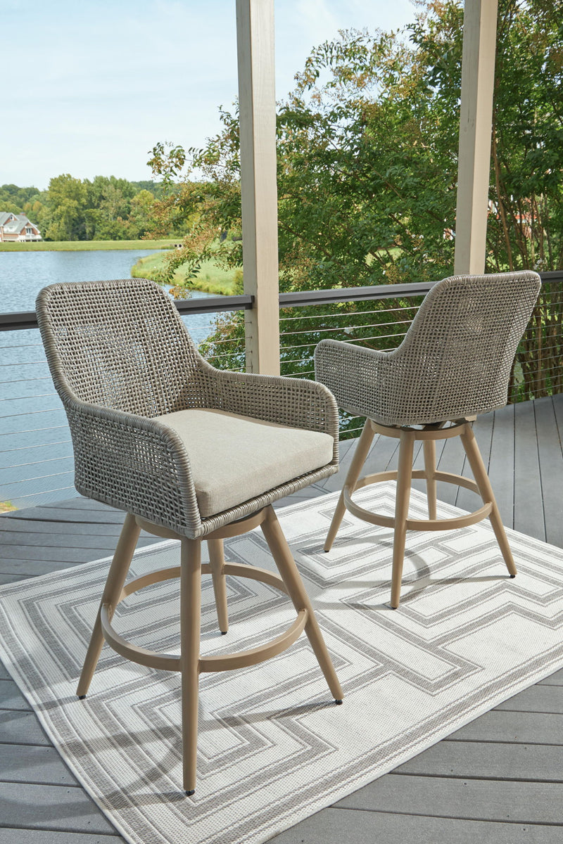 Set of two woven barstools with beige seat cushions and light wood frames