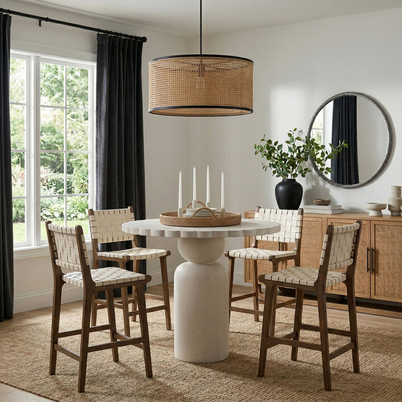 Beige round pedestal dining table with scalloped top and slender base