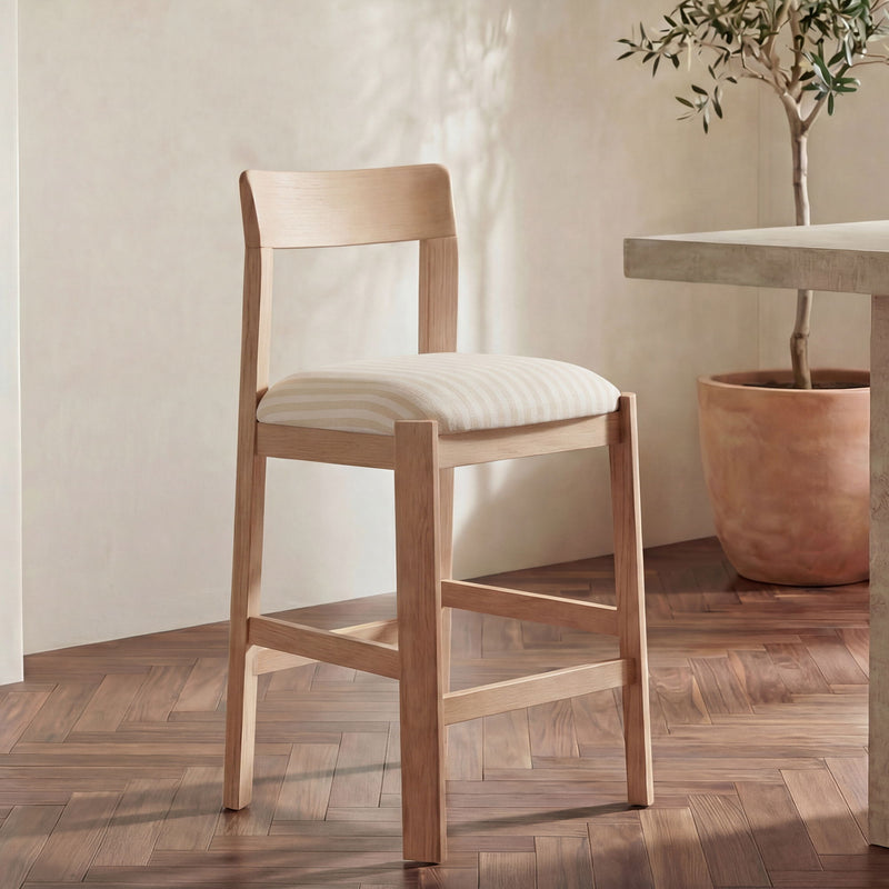 Light wood counter stool with striped cushioned seat and open slat back, angled