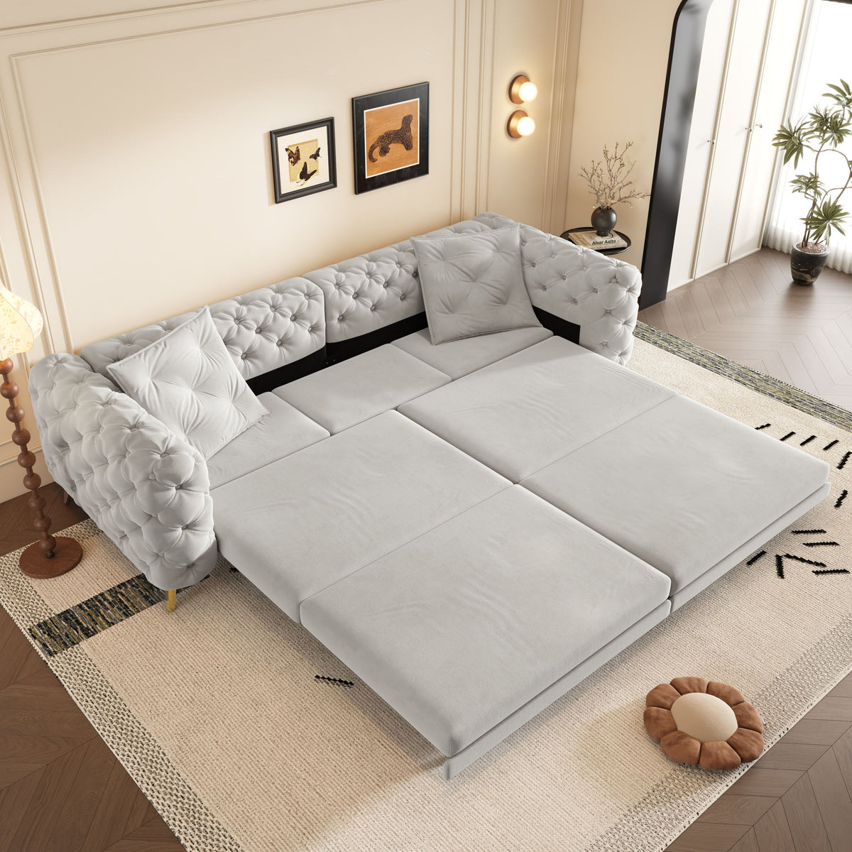 Gray convertible sleeper sofa open as a bed, with tufted back and rolled arm sections