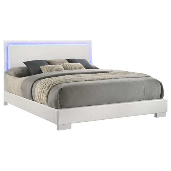 White panel bed with blue LED-lit headboard and gray mattress with pillows