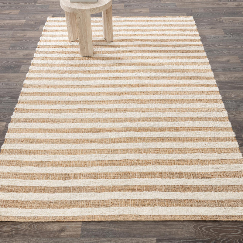 Natural stripe area rug with horizontal bands under a partial chair leg