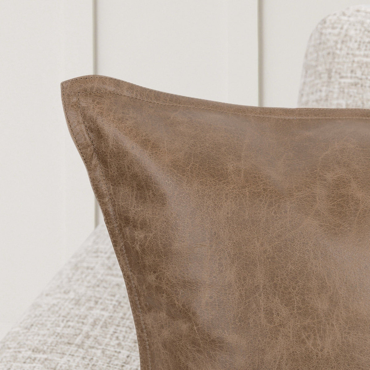 Taupe leather accent pillow, close-up of stitched panel texture