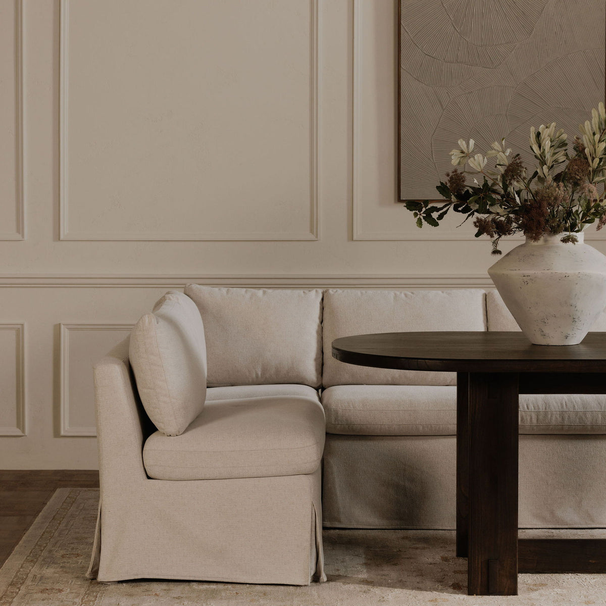 Beige slipcovered slipper chair with side profile, wide padded seat and arms