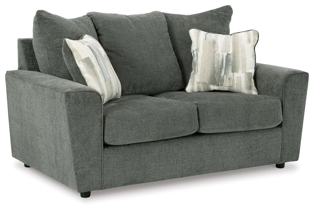 Gray upholstered loveseat with two seat cushions, rounded arms, and striped throw pillows