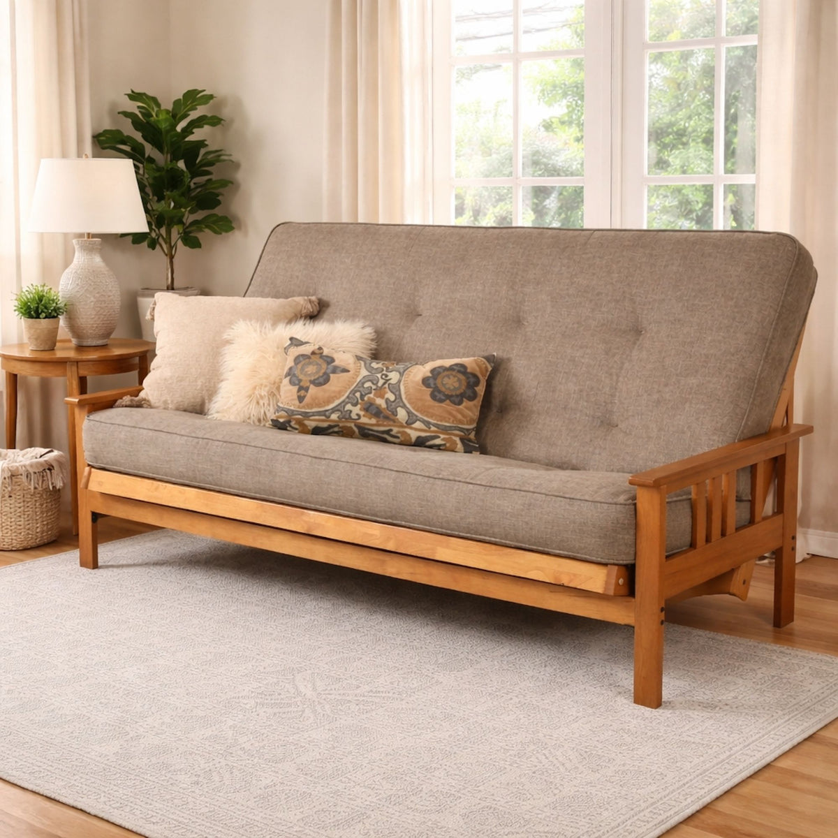 Queen-size futon frame sofa with gray fabric, tufted back, and patterned throw pillow