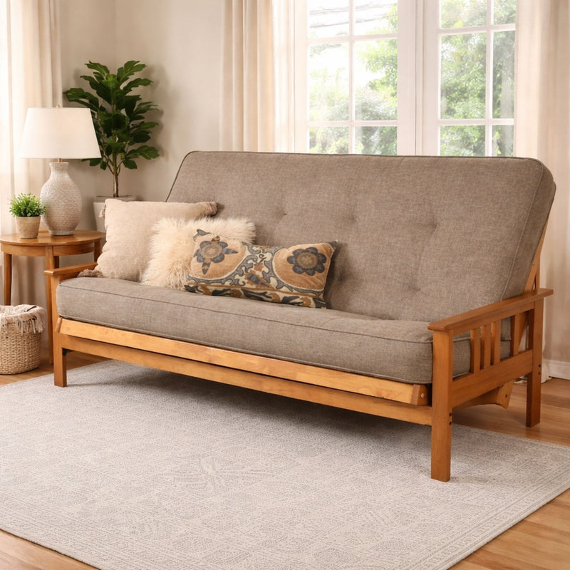 Queen-size futon frame sofa with gray fabric, tufted back, and patterned throw pillow