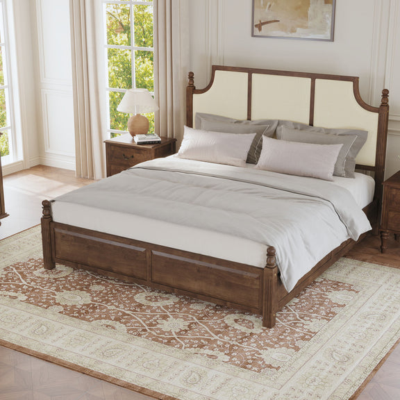 Upholstered platform bed with tall headboard, brown frame, cream panels, made bed