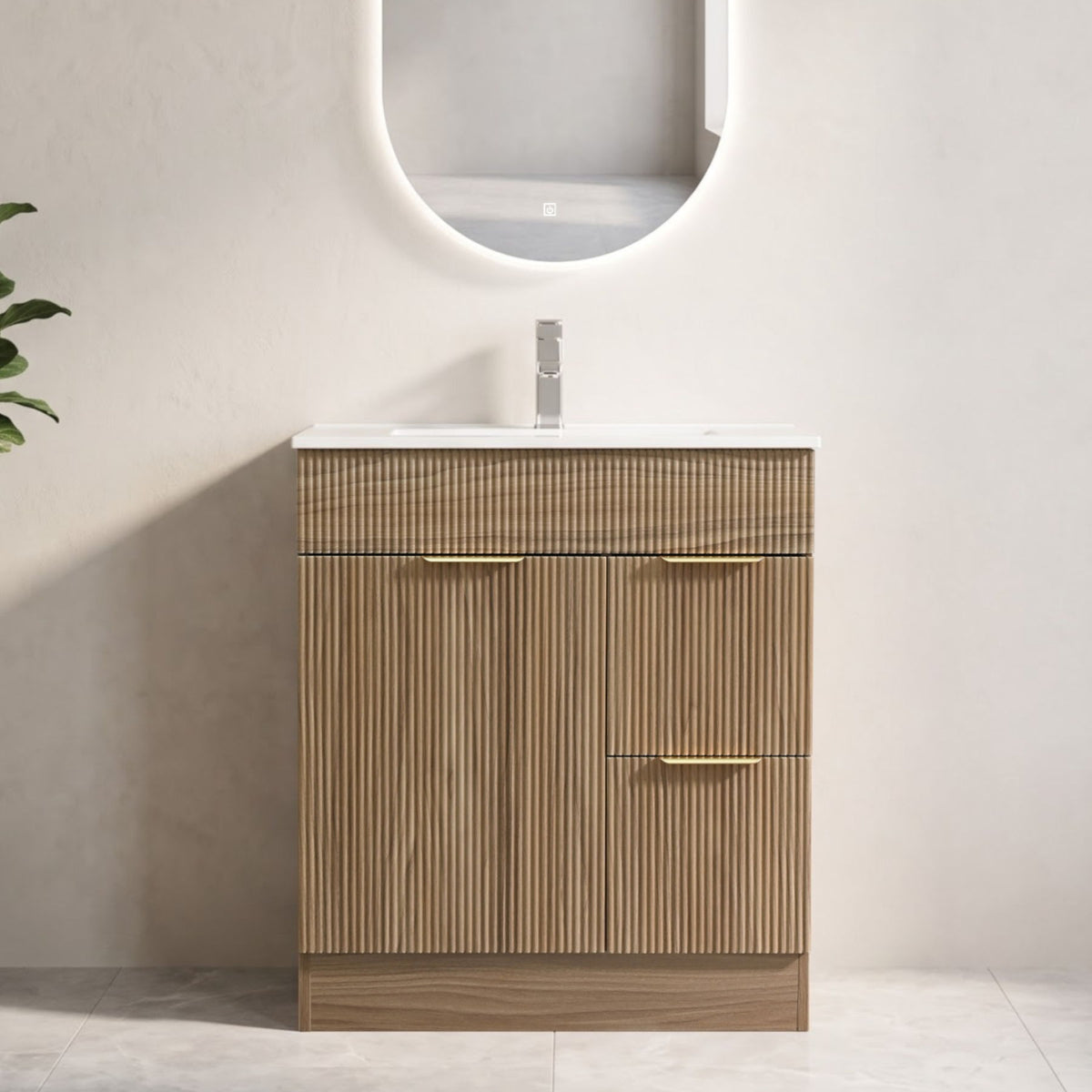 Front view of walnut bathroom vanity with fluted door and drawers, white sink, and gold handles