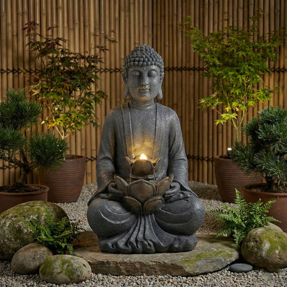 Gray seated Buddha water fountain with glowing bowl and LED light, garden scene