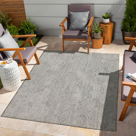 Indoor/outdoor area rug with light gray chevron pattern and flat woven surface.