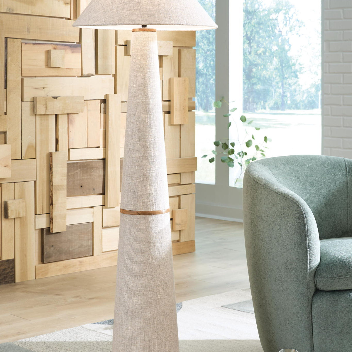 Beige fabric floor lamp with conical shade and tall metal pedestal base, wood-tone ring