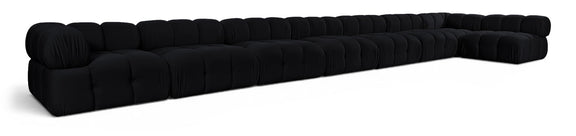 L-shaped velvet sectional sofa in black with tufted cushions and rolled arm details