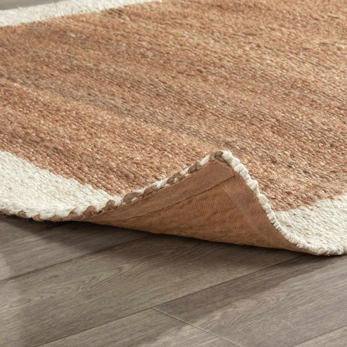 Frame area rug corner detail with ivory edge and tan top, showing folded pile