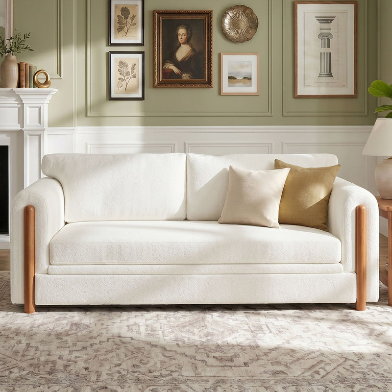 White 3-seat upholstered couch with wooden legs and three back pillows