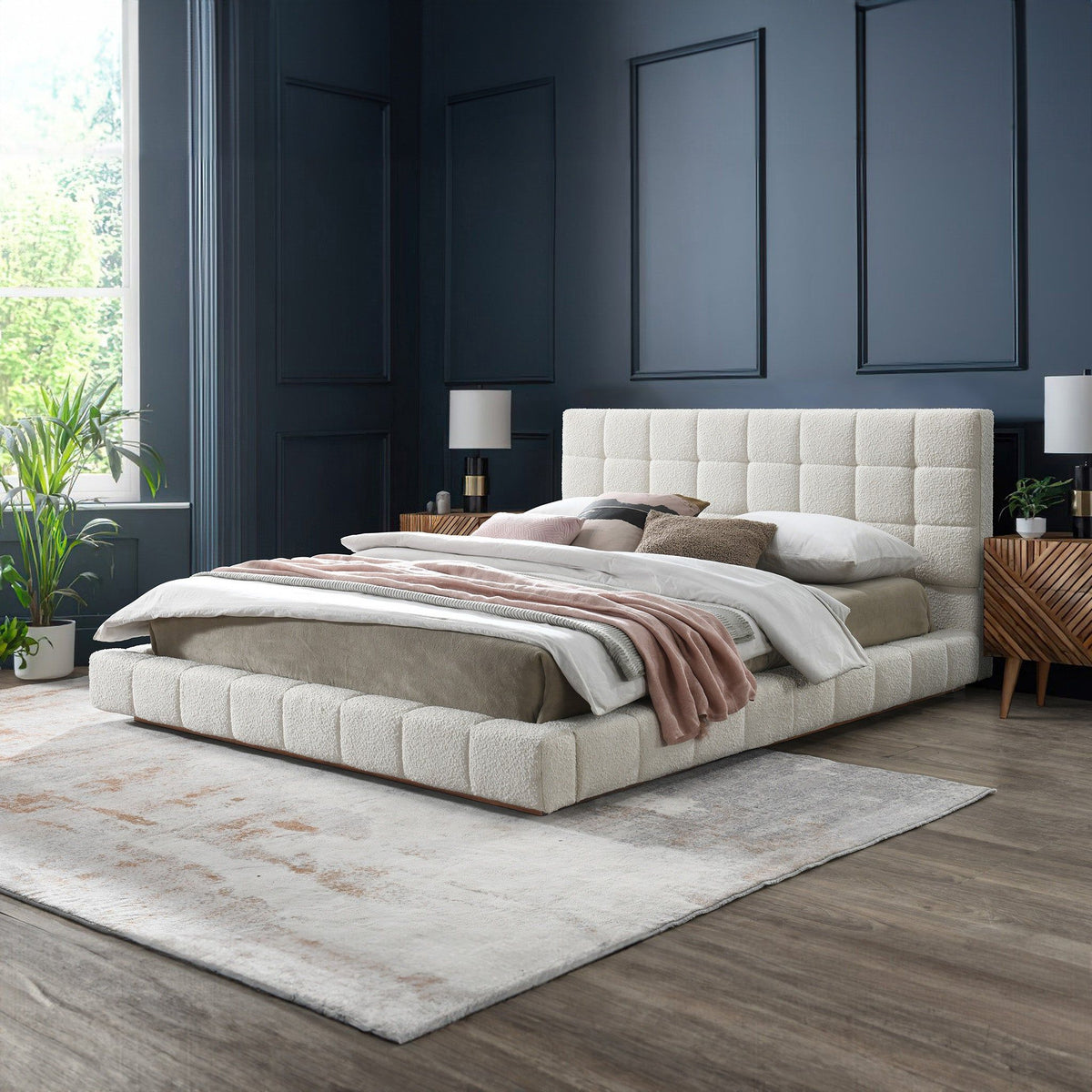 Beige upholstered bed with tufted headboard and neatly made striped blanket