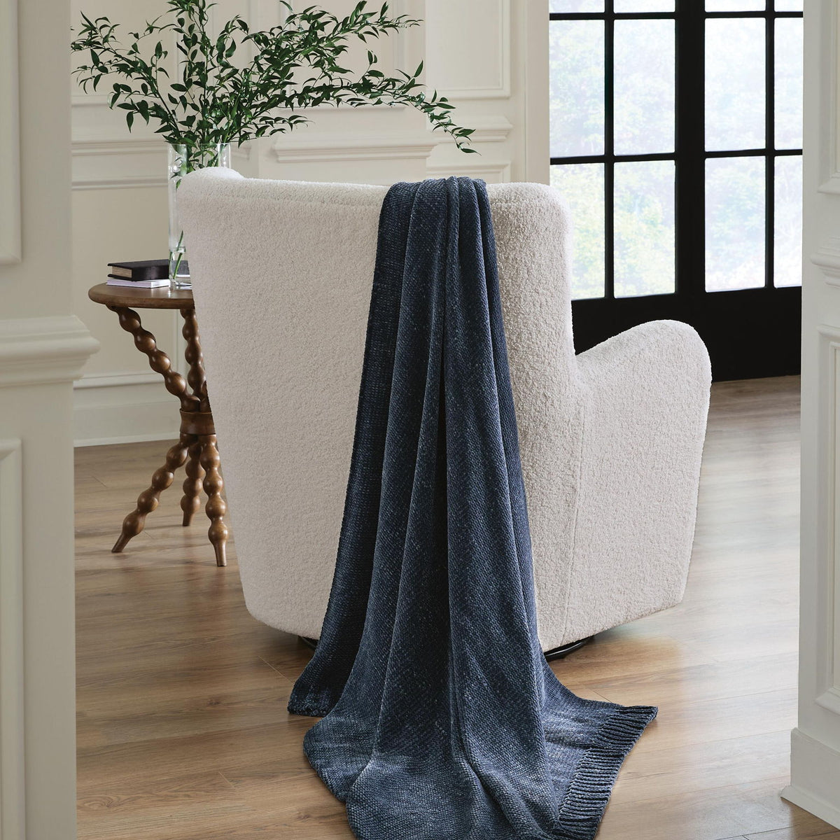 Anawood throw draped over armchair in dark blue