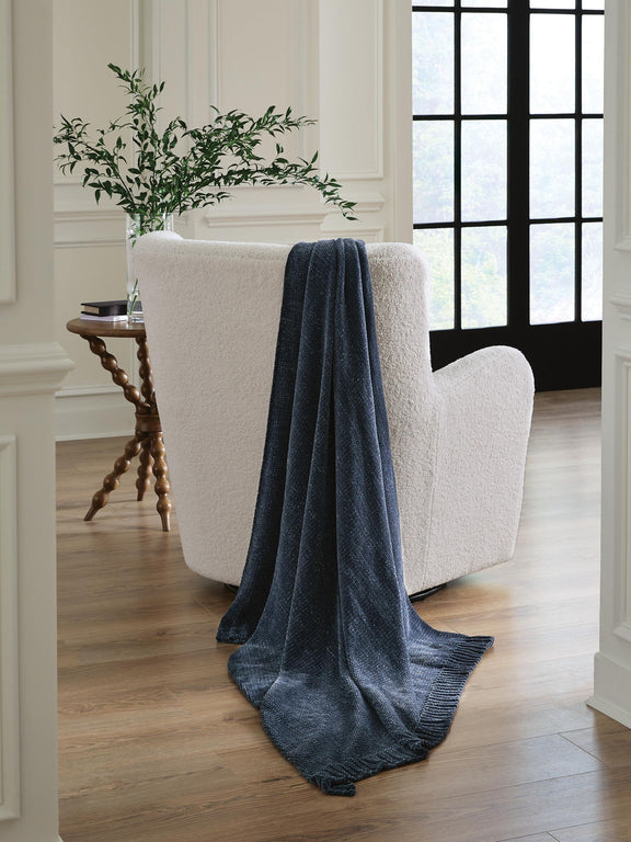 Anawood throw draped over armchair in dark blue