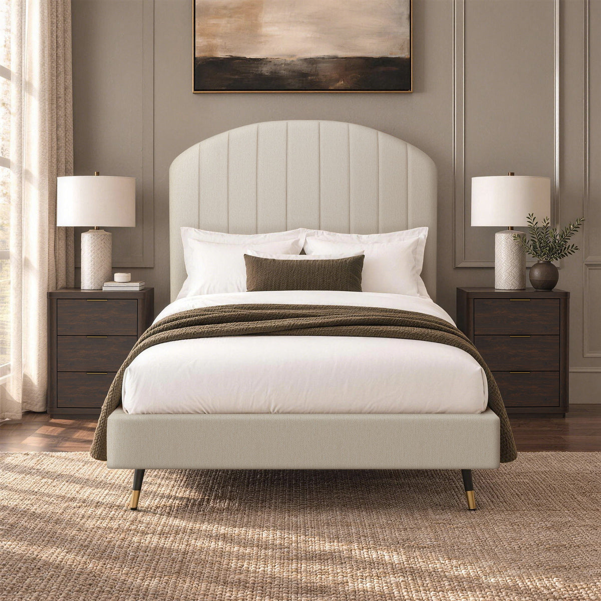 Beige arched upholstered bed with white bedding and dark throw blanket
