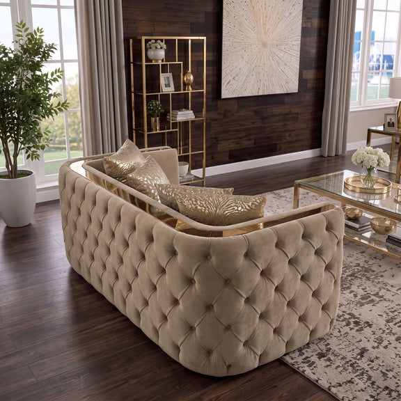 Light brown button-tufted loveseat with gold-tone side rails and patterned throw pillows